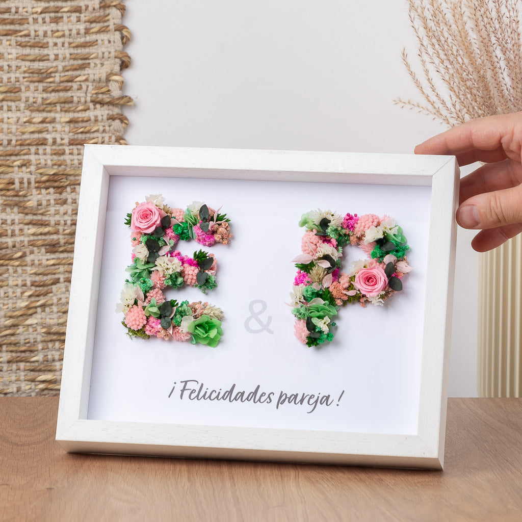 cuadro con dos iniciales con flores preservadas