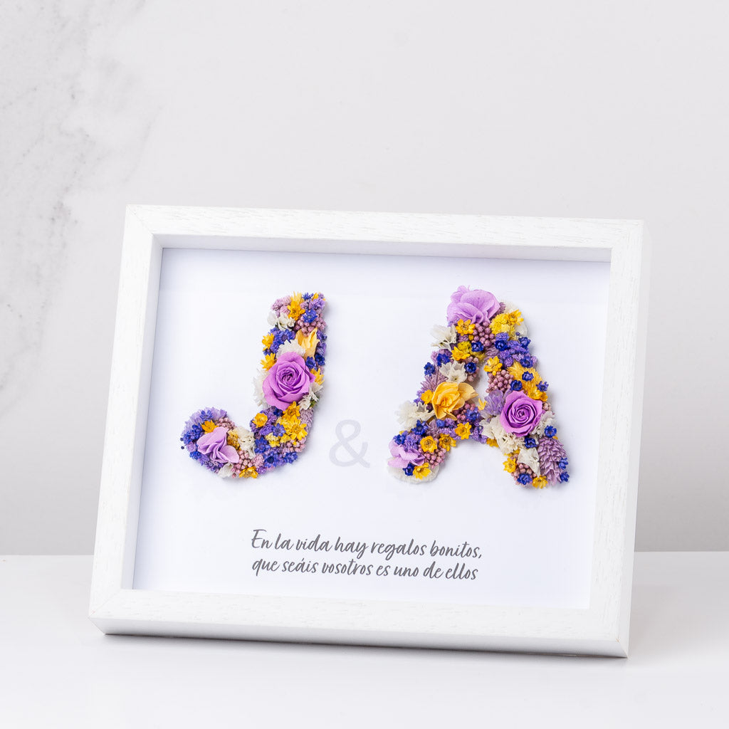 cuadro con dos iniciales con flores preservadas
