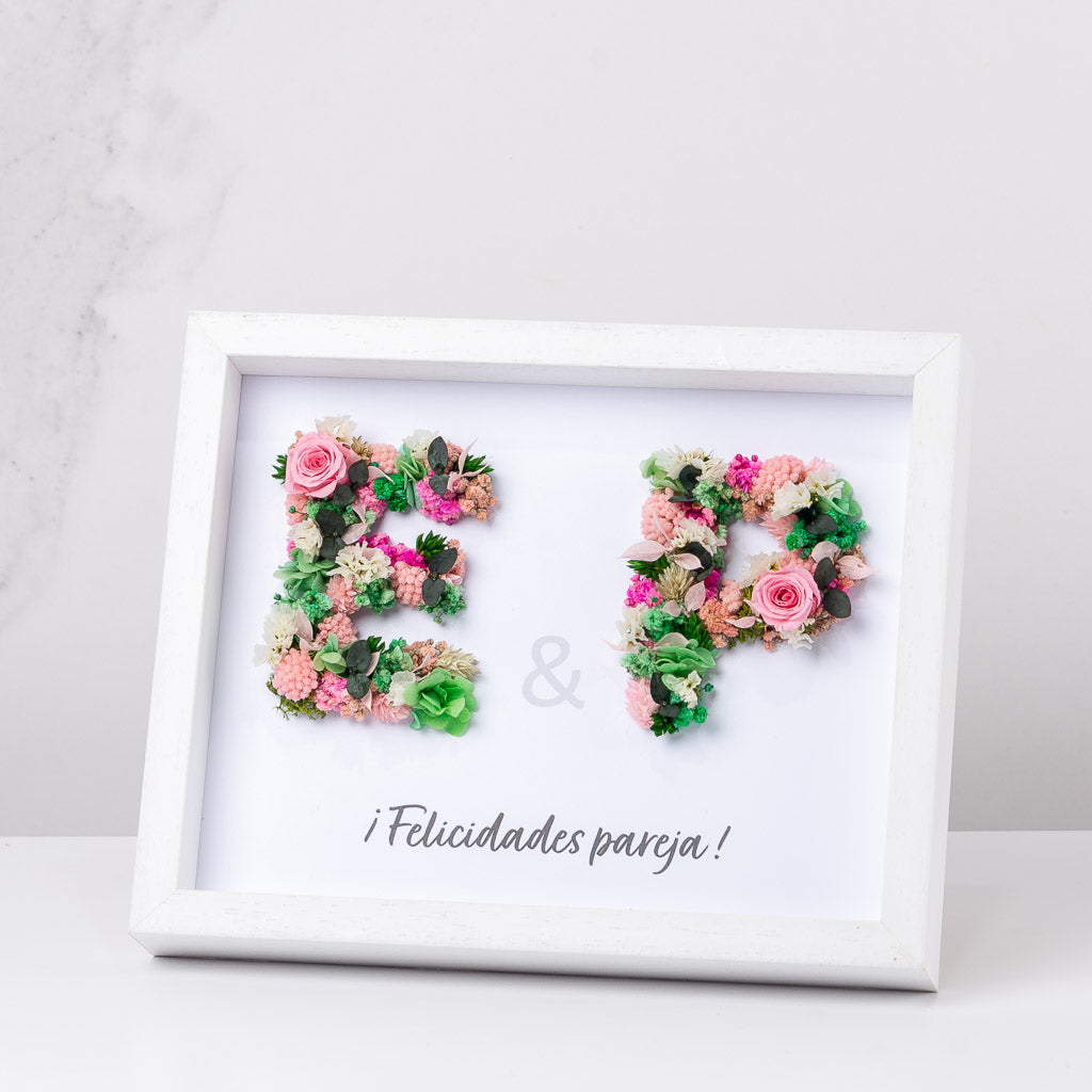 cuadro con dos iniciales con flores preservadas
