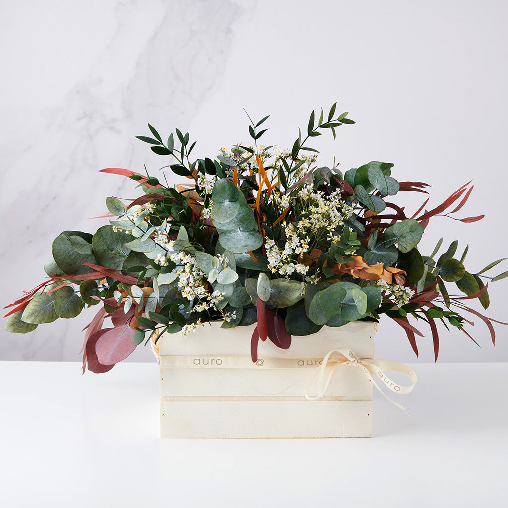 centro de eucaliptus preservados y flores blancas