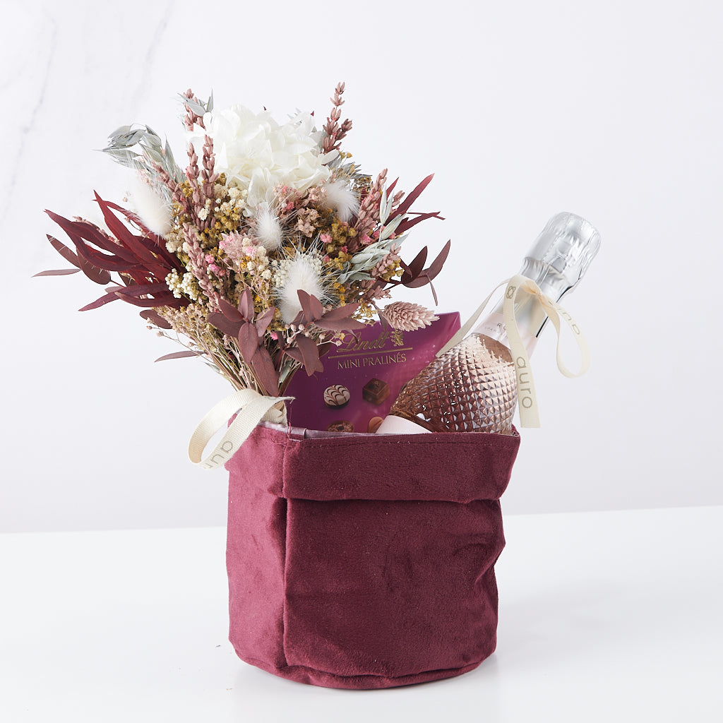 cesta de tela con cava, minipralinés y cava Freixenet Roseé