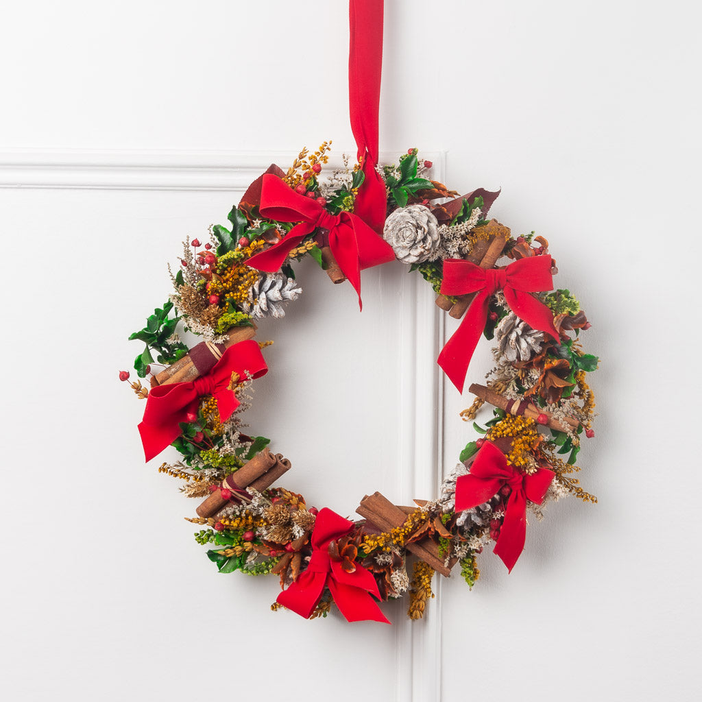 corona de navidad con flores y verdes preservados