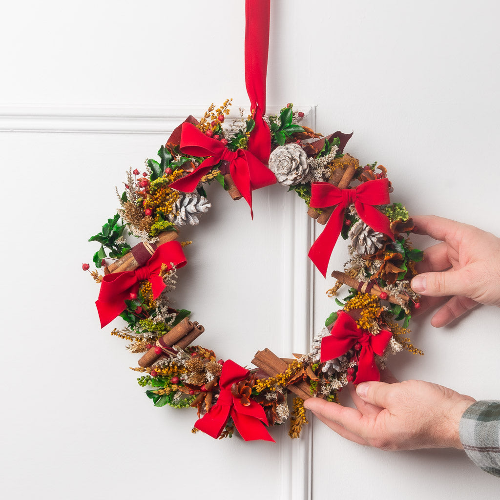 corona de navidad con flores y verdes preservados