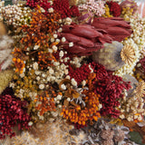 detalle de flores preservadas y proteas rojas
