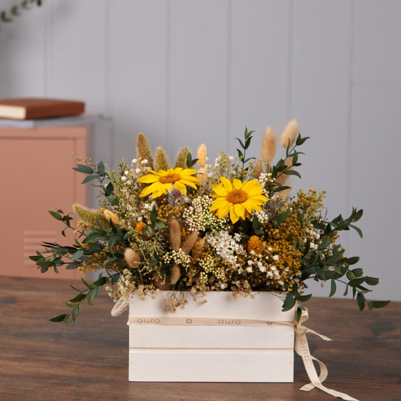 decoración con centro de flores preservadas en caja de madera con girasoles y eucaliptus preservados