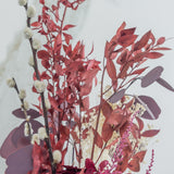 Detalle de ramillete de flores preservadas en tonos granate