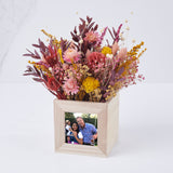 centro en tonos ocres de flores preservadas y fotografía adjunta