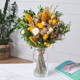 ramo de flores preservadas con margaritas amarillas y cremas