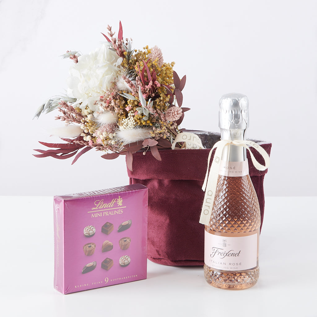 cesta regalo de ramito de flores, minicava freixenet rosé y mini pralinés lindt